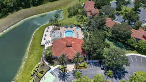 Eine Vogelperspektive eines Resorts mit Schwimmbad, Tennisplatz und Parkplatz.
