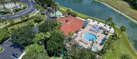 Un resort con piscina, sillas de descanso y cancha de tenis.