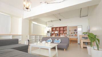 A modern living room with a sofa, a coffee table, and a bookshelf.