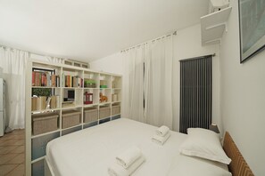 Une chambre d’hôtel avec un grand lit, une bibliothèque et un radiateur.