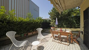 An outdoor patio with a table and chairs, a small round table, and a potted plant. - Casa Matilda in Sirmione (Sirmione)