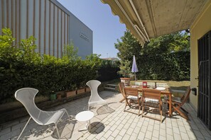An outdoor patio with a table and chairs, a small round table, and a potted plant. - Casa Matilda in Sirmione (Sirmione)