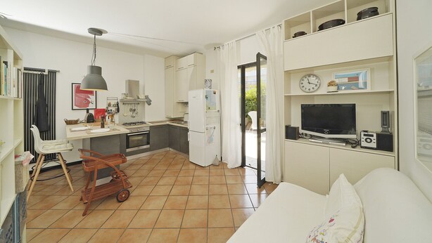 A compact living space with a kitchenette, a dining area, and a seating area with a television and audio equipment. - Casa Matilda in Sirmione (Sirmione)