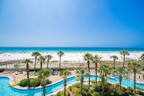 Et resort med swimmingpool, strand og palmer.
