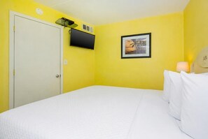 A room with a bed, a television mounted on the wall, and a framed picture. - Island Winds East 404 1 Bedroom Condo (Gulf Shores)