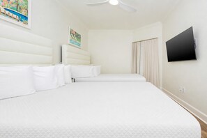 A hotel room with a large bed, a flat-screen TV, and a ceiling fan. - The Oasis 1008 Formerly Phoenix West Ii 1008 3 Bedroom Condo (Orange Beach)