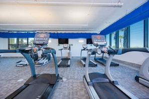 Ein Fitnessraum mit Laufbändern, Ergometer und einer Gewichtshalterung.
