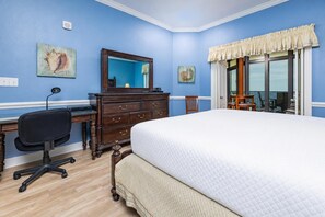 Ein Schlafzimmer mit Bett, Kommode, Schreibtisch und Stuhl.