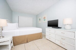 A bedroom with a bed, a television, a dresser, and a nightstand. - Island Winds East 210 2 Bedroom Condo (Gulf Shores)