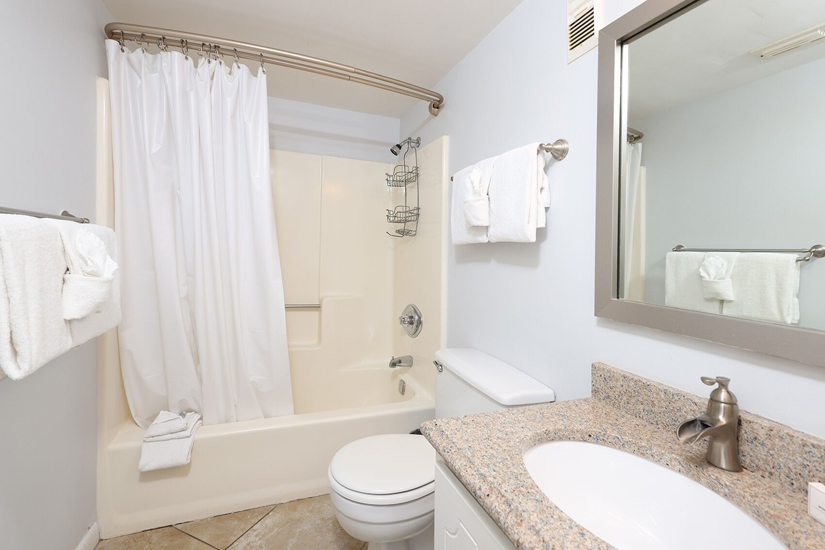 Ein modernes Badezimmer mit Badewanne, Toilette, Waschbecken und einem großen Spiegel.