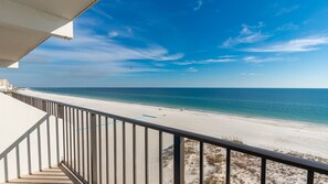 Ein Balkon mit Blick auf Strand und Meer.