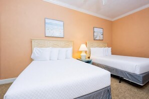 A hotel room with two beds, a nightstand with a lamp, and two wall-mounted pictures. - The Oasis 1003 Formerly Phoenix West Ii 1003 3 Bedroom Condo (Orange Beach)
