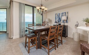 Un espace repas comprenant une table, des chaises et un lustre.