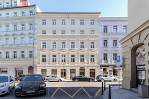 A multi-story hotel with a classic architectural style, featuring a central entrance with a grand staircase, and a parking area in front. - My Second Home - Soukenická 36 Residence (Hlavní město Praha)