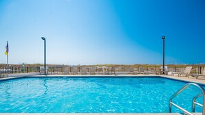 Uma piscina com espreguiçadeiras e uma bandeira.