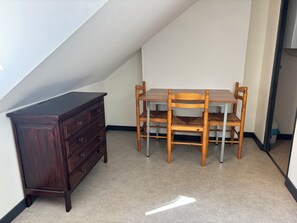 A room with a wooden dresser, a dining table with chairs, and a sloped ceiling. - Chambre privative dans maison partagée  (FRANCE)