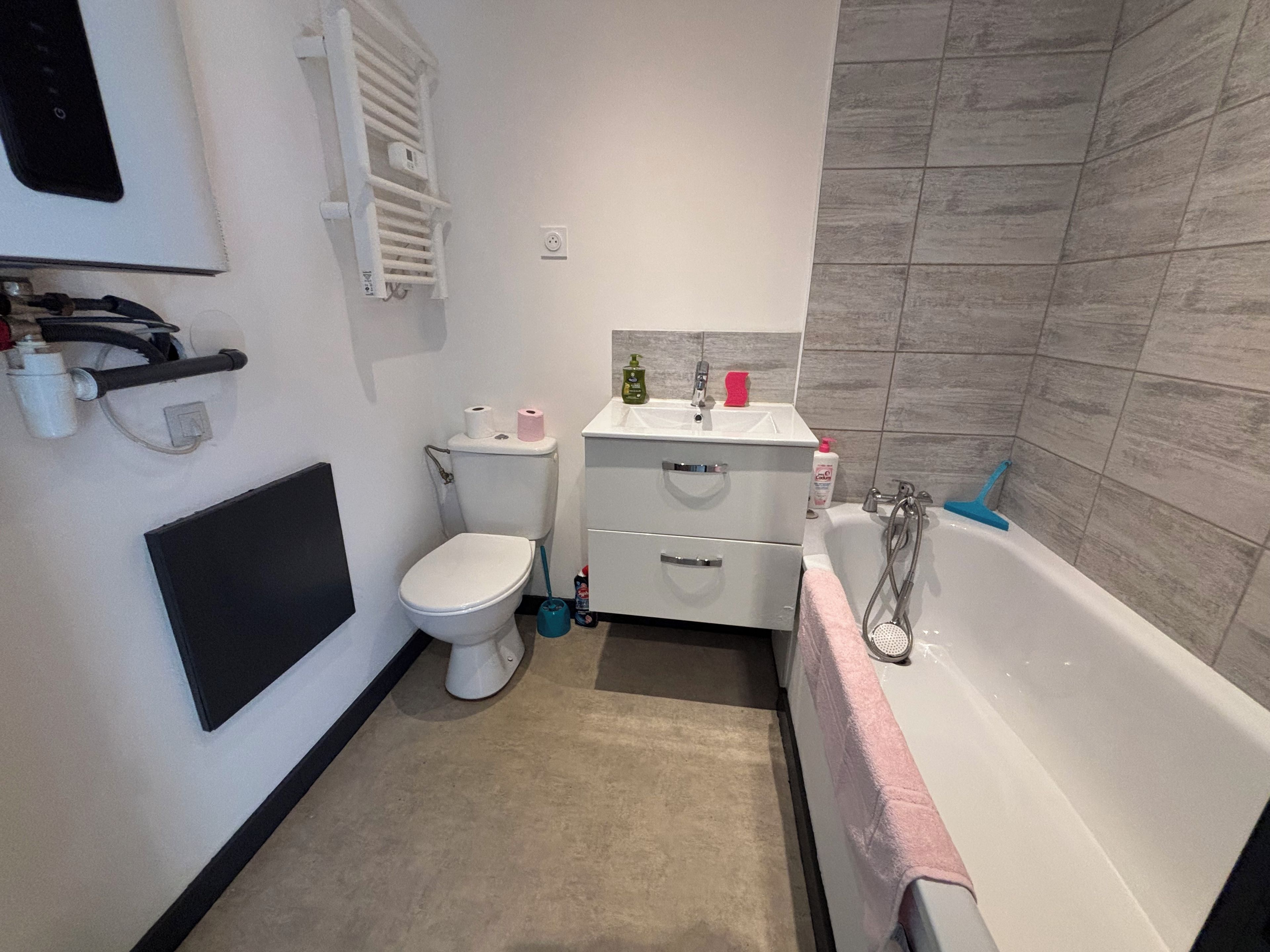 Een badkamer met toilet, wastafel en bad.