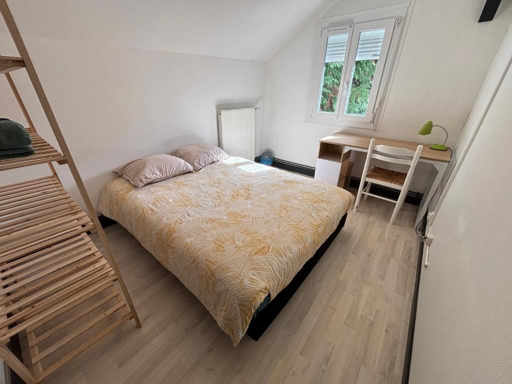 Une chambre à coucher avec un lit, un bureau et une chaise.