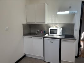 A compact kitchen with a microwave, sink, and dishwasher.