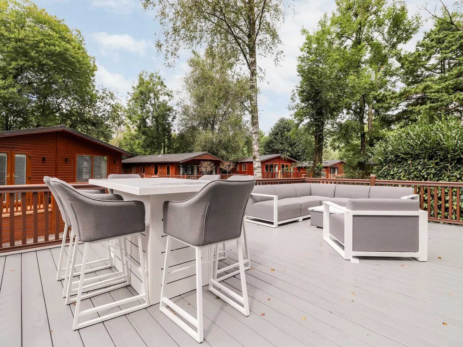 Eine Terrasse mit Gartenmöbeln, darunter ein Tisch, Stühle und eine Sitzecke.