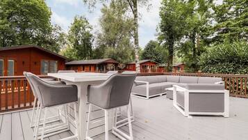Eine Terrasse mit Gartenmöbeln, darunter ein Tisch, Stühle und eine Sitzecke.