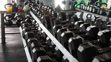 Ein Fitnessraum mit Reihen von Kurzhanteln und Kettlebells.