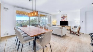 A modern living room with a dining area, large windows, and a flat-screen TV. - Vista El Yeco | Vista al mar y acceso a playa (Algarrobo)