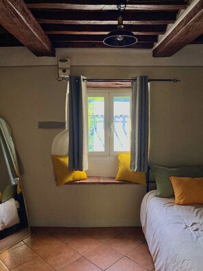 A room with a window, a bed, a mirror, and a ceiling light fixture. - La Salvia • 1864 Stone House by the Lima River (Bagni di Lucca)