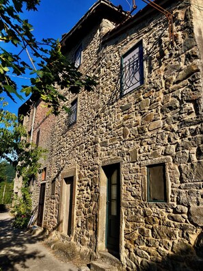 A stone building with multiple windows and doors, surrounded by trees. - La Salvia • 1864 Stone House by the Lima River (Bagni di Lucca)