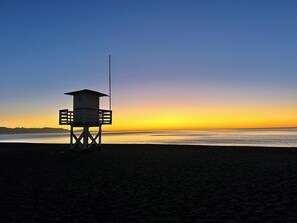 A lifeguard tower on a beach at sunset. - LOLA Beachfront Garden Apartment | Pools, Direct Beach Access, and Family-Friendly (Torremolinos)