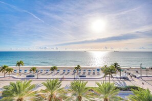 A beach with rows of blue umbrellas, palm trees, and a clear view of the ocean. - 3 High-rise Beach Condos! Views, Resort Perks (Fort Lauderdale)