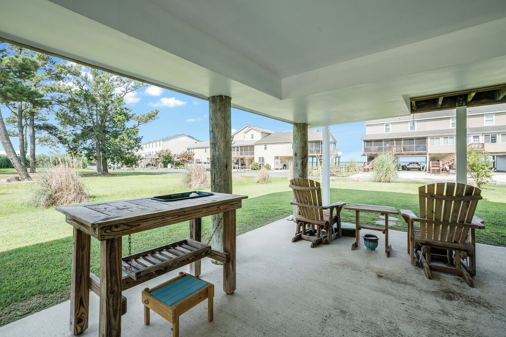 An outdoor patio area with a wooden table, chairs, and a bench.