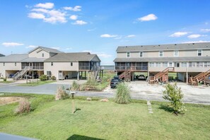 A hotel with a two-story structure, outdoor parking, and a view of the sea. - Saltwater Revival - Stay with Seaside Vacations! (Chincoteague Island)