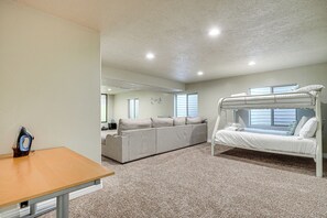 Une chambre avec un lit superposé, un canapé et une table.