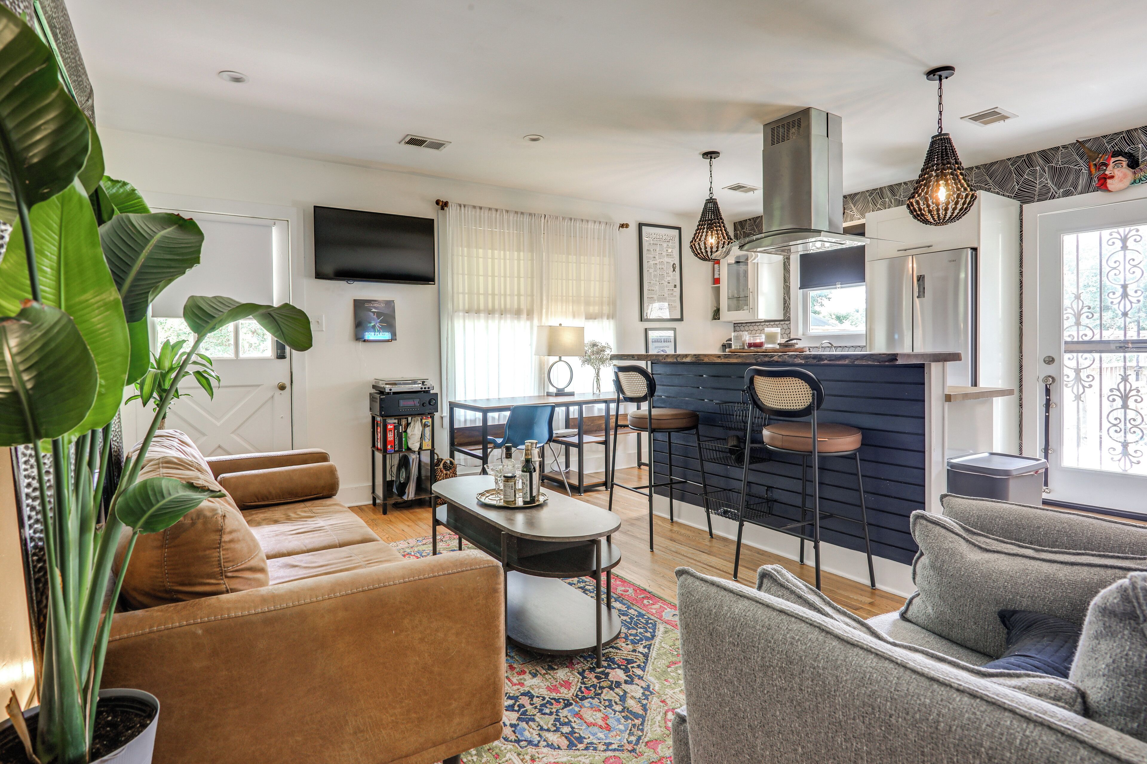 Un salon moderne comprenant un canapé, une table basse et un coin repas avec des chaises.