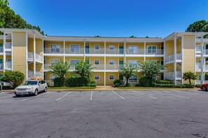 Ein mehrstöckiges Hotel mit Parkplatz davor.