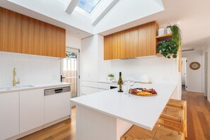 Eine moderne Küche mit einer zentralen Kochinsel, Holzschränken und einem Oberlicht.