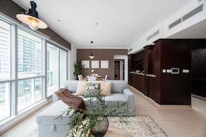Ein modernes Wohnzimmer mit einer Couch, einem Couchtisch und einem großen Fenster.