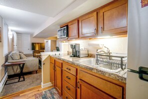 A compact kitchen with wooden cabinets, a microwave, a toaster, and a sink. - Walk to Grand Ave Shops & Dining! Cozy St Paul Apt (St. Paul)