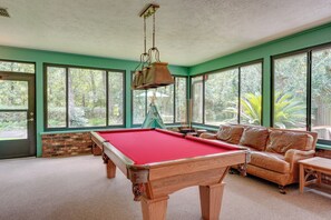 A pool table in a room with large windows, a sofa, and a hanging lamp. - 2 Mi to Silver Springs State Pk! Family Hideaway (Silver Springs)
