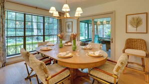 A dining room with a round table set for six, surrounded by wicker chairs, large windows, and a chandelier. - 2 Mi to Silver Springs State Pk! Family Hideaway (Silver Springs)