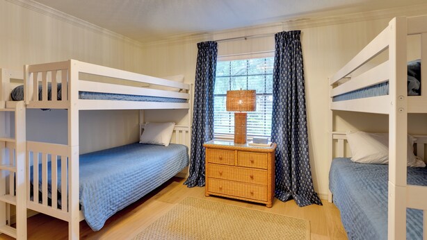A bunk bed room with a central nightstand, a window with curtains, and a wooden floor. - 2 Mi to Silver Springs State Pk! Family Hideaway (Silver Springs)