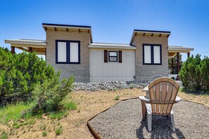 A modern two-story house with a covered patio area.