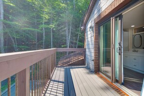 A wooden deck with a glass door leading to a bathroom with a sink and mirror. - Near Beaches & Golf! All-seasons Gem in N Monmouth (North Monmouth)