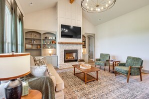 A spacious living room with a fireplace, a television, and comfortable seating.