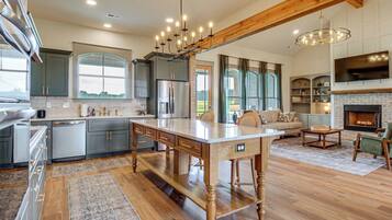 A spacious kitchen with a large island, modern appliances, and a dining area with a fireplace.