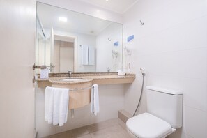 A bathroom with a toilet, sink, and mirror. - Beautiful Apart With Pool in Luxury Resort Jbv152 (Florianópolis)