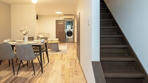 A modern interior with a dining area, a staircase, and a laundry room. - AYA - Self Check-In Only (Osaka, Chuo Ward)