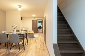 Ein modernes Interieur mit Essbereich, Treppe und Waschraum.