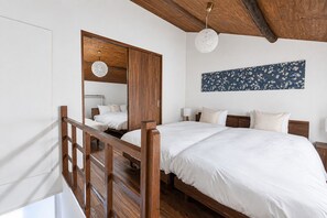 A bedroom with a wooden bed, a wardrobe, a hanging light fixture, and a floral wall art piece. - AYA - Self Check-In Only (Osaka, Chuo Ward)
